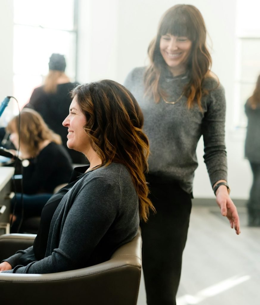 woman in black long sleeve shirt sitting on beige chair